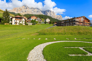Fototapeta na wymiar Green meadow in San Cassiano village, Dolomites Mountains, Italy