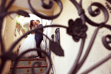 Bridal couple kissing on staircase