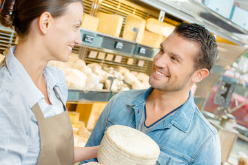 Shop assistant serving cheese