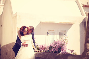 Bridal couple kissing on vintage balcony