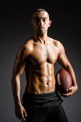 Muscular football player with ball
