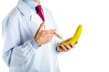 Doctor in white coat making an injection to a banana