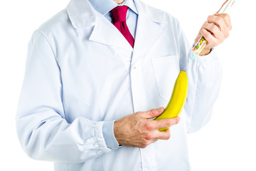 Doctor in white coat making an injection to a banana