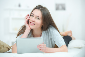 Woman laying on a sofa with her tablet