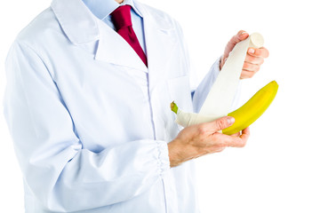 Doctor in white coat bandaging a banana