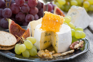 camembert with honey and fruit, snack on a plate