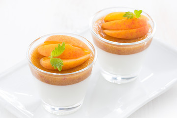 dessert with cream and apricot jelly in glasses, top view