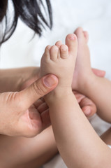 closeup shot of mother's hands holding baby's feet