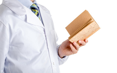 Man in medical coat reading blank cork book