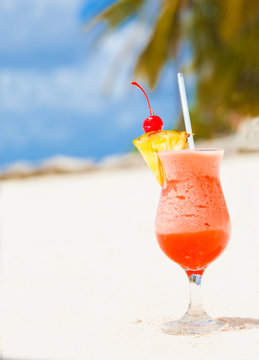 glass of fruit cocktail  and heart shaped sunglasses on table