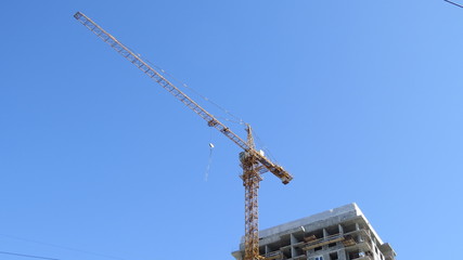 Naklejka premium The construction crane is preparing to raise another plate