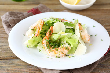 Salad with shrimps, lettuce and cheese on a plate