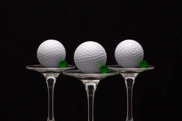 Three glasses of champagne and golf balls