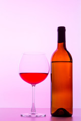 Red Wine bottle and glass on pink background