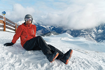Fototapeta na wymiar Male snowboarder against panoramic winter mountains background