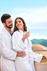 Obraz premium Couple in bathrobe standing on hotel balcony.