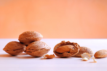 Almonds on a white table and orange background