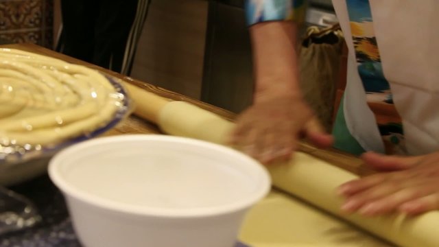 male chefs hands preparing dough with rolling pin for asian food