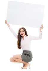 Woman crouching with blank sign