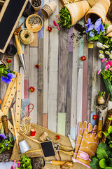 Fototapeta premium Garden tools, flowers and seeds on a wooden background, frame