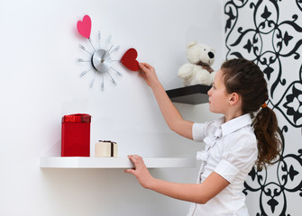 Little girl  looking at a clock on the wall