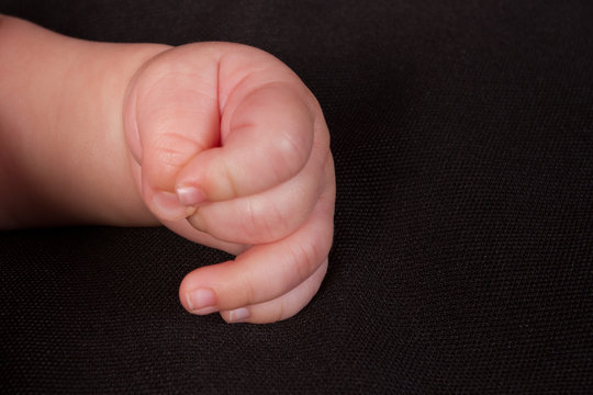 Parent's hand holding newborn
