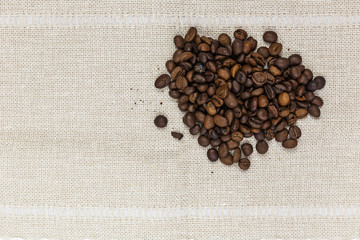 A handful of coffee beans on sackcloth