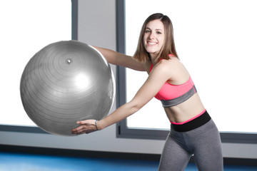smiling woman with exercise ball in gym.