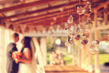 Bride and groom with light bulbs hanging