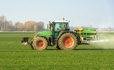 Naklejka premium XXX - Traktor mit Düngerstreuer auf dem Kornfeld - 8946