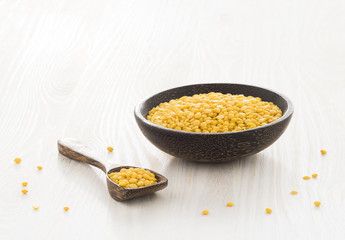 Gelbe Linsen (Lens culinaris), Holzschale, Holzlöffel