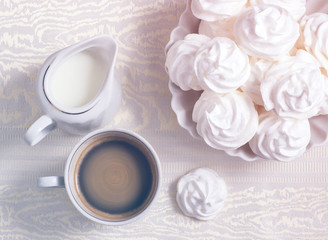 meringue cookies and a cup of coffee with cream