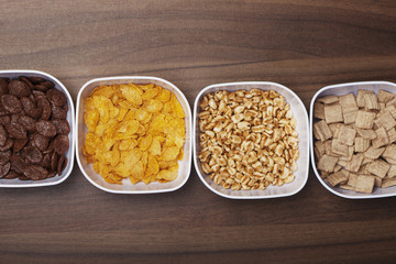 Cornflakes in verschiedenen Sorten, Schüsseln auf Holz