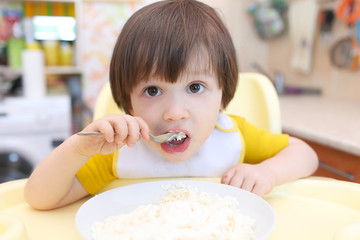 Nice little child eats quark
