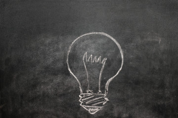 Light bulb on a black chalkboard