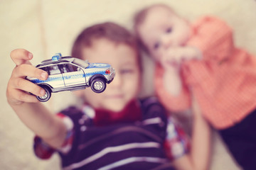 Brothers playing with a car