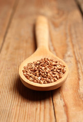 Buckwheat in a spoon on a wooden table