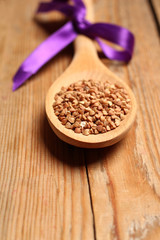 Buckwheat in a spoon on a wooden table