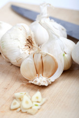 Knoblauch auf Holzbrett mit Messer,