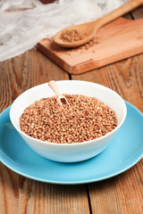 Buckwheat in a bowl on a wooden table