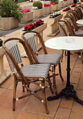 french sidewalk cafe with small round tables and wicker chairs - 81493501