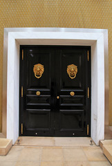 Black wooden door with knob in the shape of brass lion, Monaco