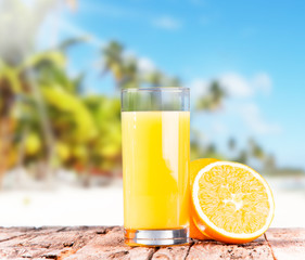  Orange juice on wooden with tropical beach 