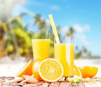  Orange juice on wooden with tropical beach 