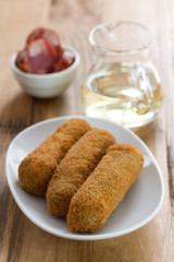 meat croquete on white dish and wine