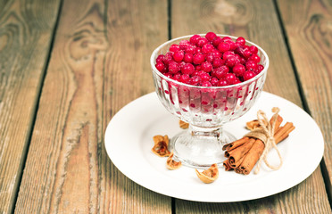 Frozen red currant berries in a glass bowl with cinnamon