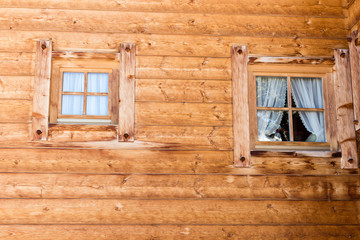 mountain cabin windows with curtains in wooden wall