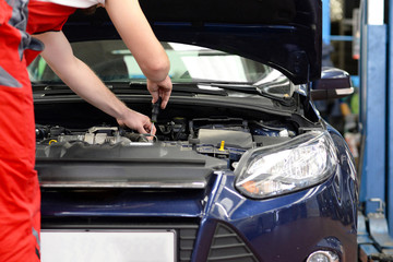 Obraz na płótnie Canvas KFZ Mechaniker repariert Motor an einem Fahrzeug