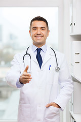 smiling doctor making handshake at medical office