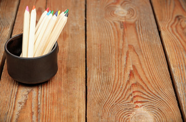 Pencils in a mug on a wooden table